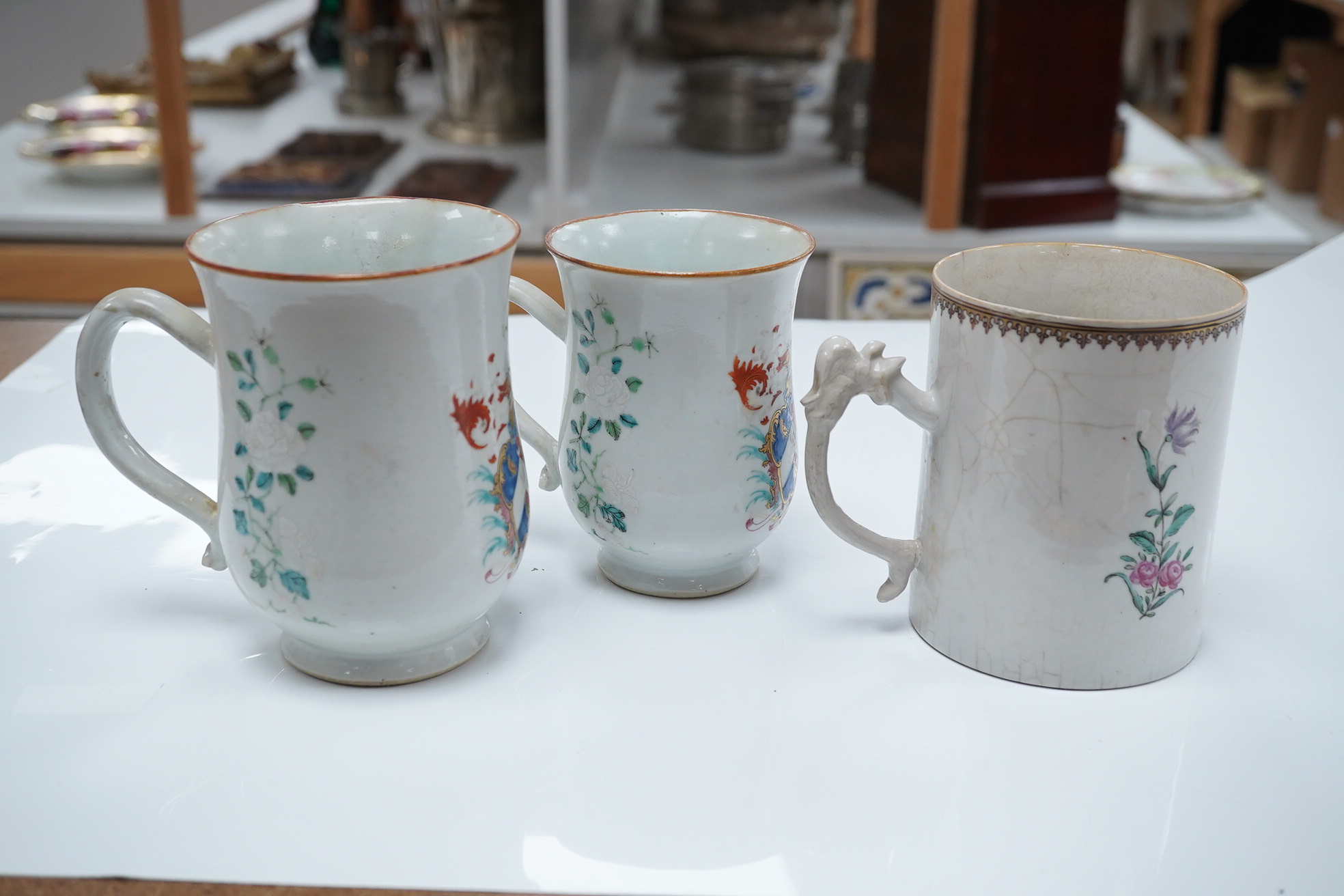 Three 18th century Chinese export armorial mugs, largest 14cm high. Condition - all restored